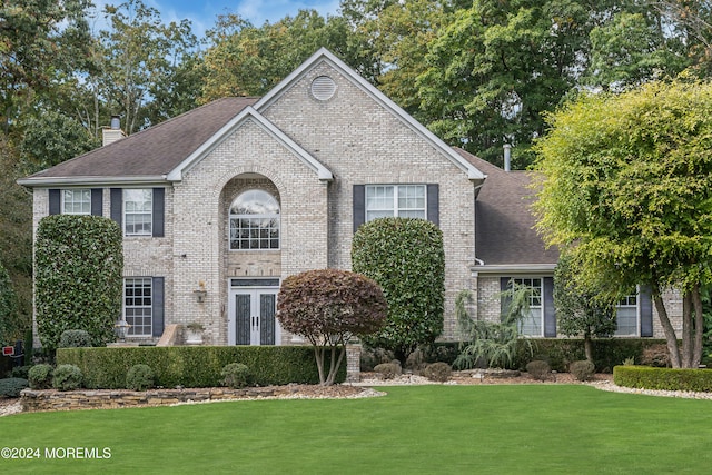 view of front facade with a front yard and french doors