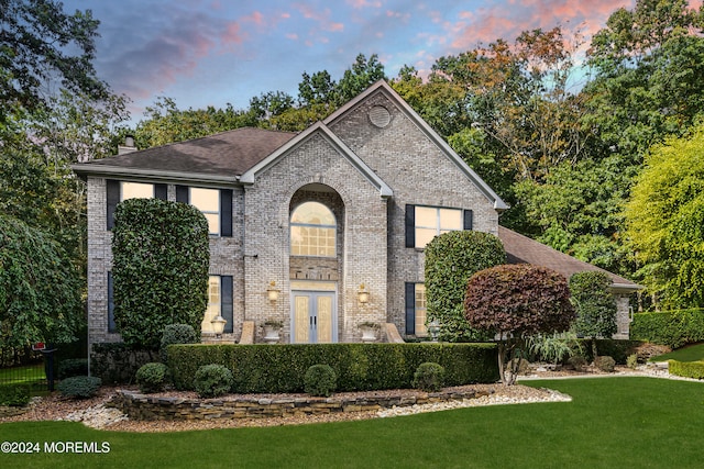 view of front of property with a lawn and french doors