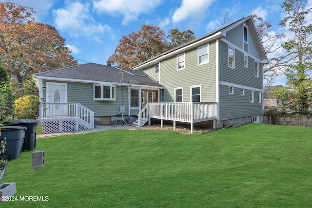 rear view of property with a yard and a deck