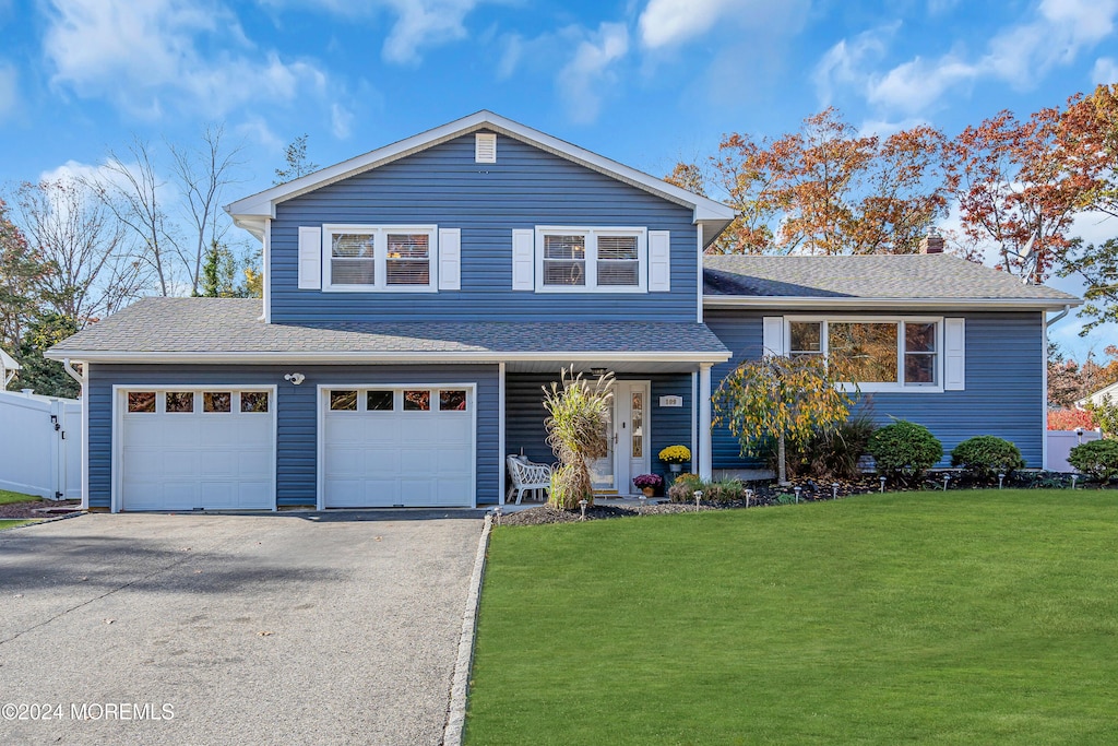 view of front of property featuring a front yard and a garage