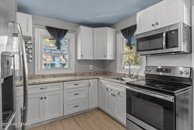 kitchen with white cabinets and appliances with stainless steel finishes