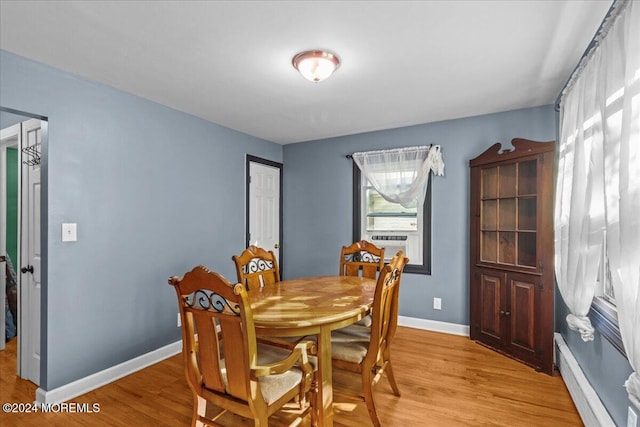 dining area featuring light wood-type flooring and a baseboard heating unit