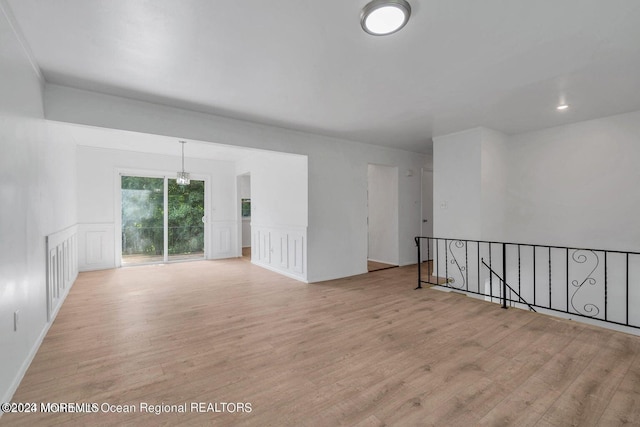 spare room with a chandelier and light hardwood / wood-style floors