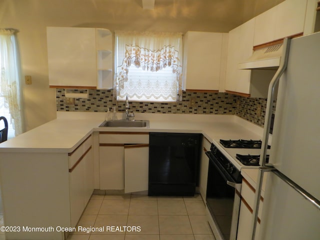 kitchen featuring exhaust hood, a sink, black dishwasher, freestanding refrigerator, and range with gas cooktop