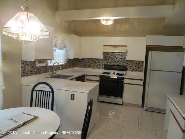 kitchen with range with gas stovetop, freestanding refrigerator, light countertops, under cabinet range hood, and a sink