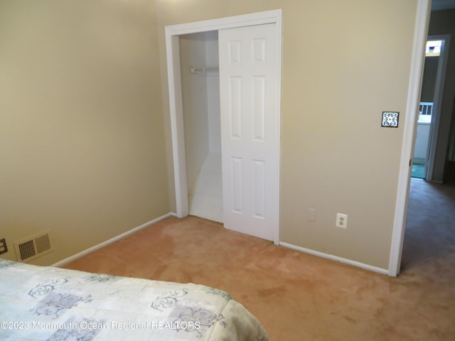 unfurnished bedroom with baseboards, a closet, visible vents, and carpet flooring