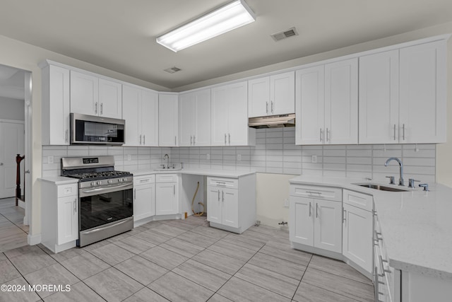 kitchen featuring decorative backsplash, stainless steel appliances, and white cabinetry