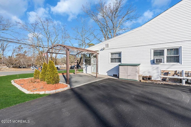 view of side of home featuring cooling unit and a pergola