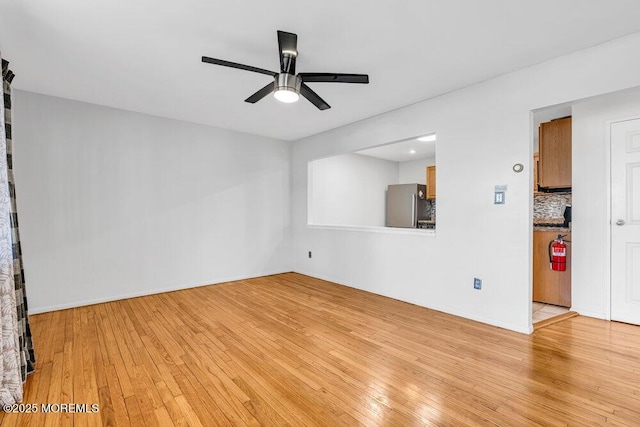 empty room with a ceiling fan and light wood-style flooring