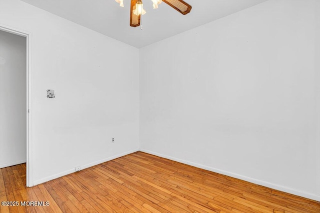 unfurnished room featuring ceiling fan, light wood-style flooring, and baseboards