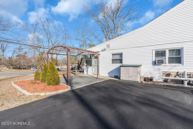 view of property exterior featuring cooling unit and a pergola