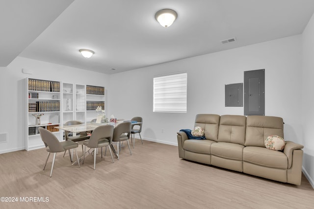 dining area with electric panel and light hardwood / wood-style flooring