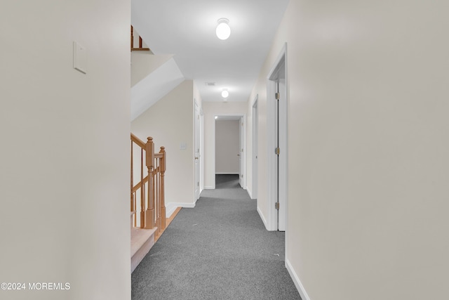 hall with dark colored carpet