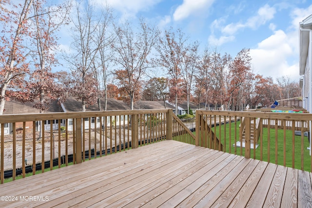 wooden deck featuring a yard and a trampoline