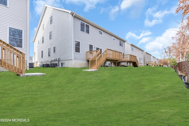 back of property with cooling unit, a yard, and a wooden deck