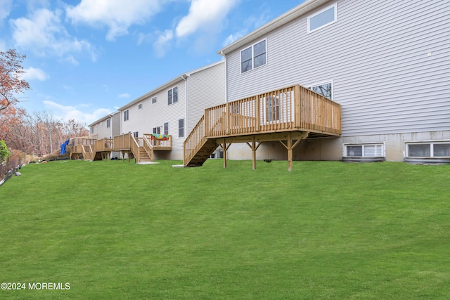 back of house with a lawn and a wooden deck