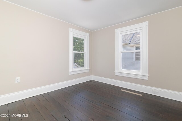 empty room with dark hardwood / wood-style flooring