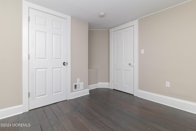 unfurnished bedroom with dark hardwood / wood-style flooring