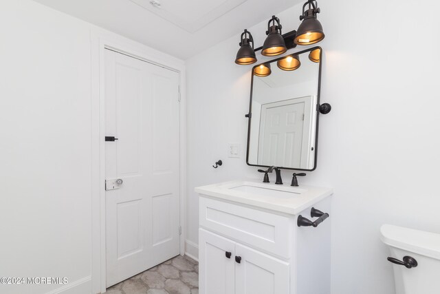 bathroom with vanity, a notable chandelier, and toilet