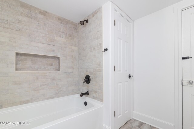 bathroom featuring tile patterned floors and tiled shower / bath