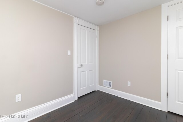 unfurnished bedroom with dark hardwood / wood-style flooring