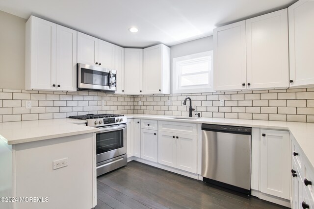 kitchen featuring appliances with stainless steel finishes, white cabinetry, and sink