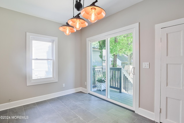 entryway with dark tile patterned floors and a chandelier