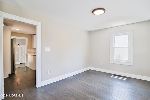 unfurnished room with dark hardwood / wood-style flooring