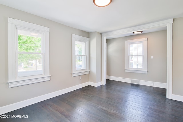 unfurnished room with dark wood-type flooring and a wealth of natural light