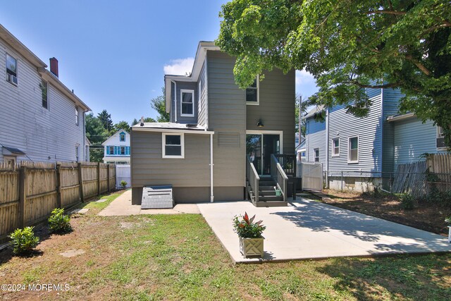 rear view of house featuring a lawn and a patio area