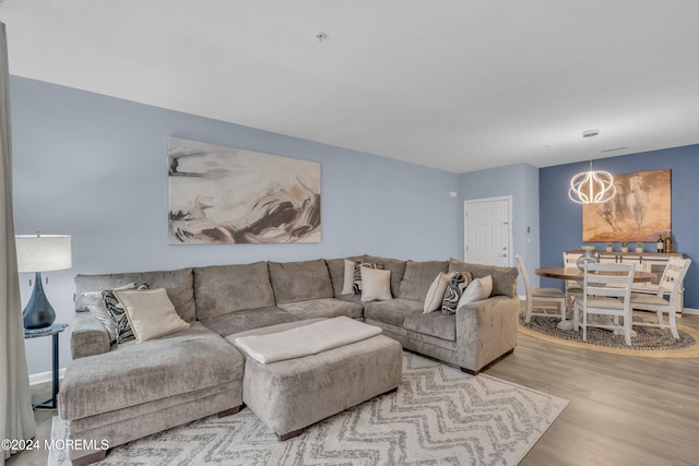 living room featuring light hardwood / wood-style floors and an inviting chandelier