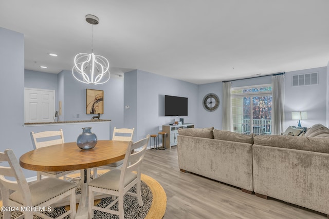 dining room with a notable chandelier and light wood-type flooring