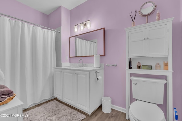 bathroom with a shower with shower curtain, vanity, wood-type flooring, and toilet