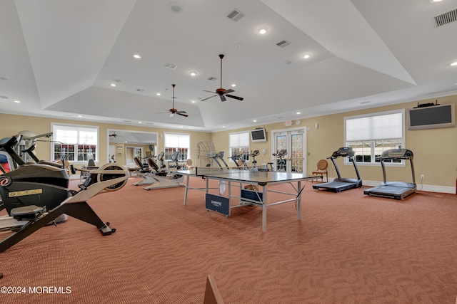 exercise room featuring carpet flooring, french doors, a raised ceiling, and ceiling fan