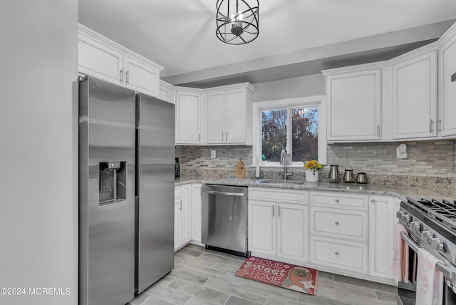 kitchen with white cabinetry, sink, stainless steel appliances, backsplash, and decorative light fixtures