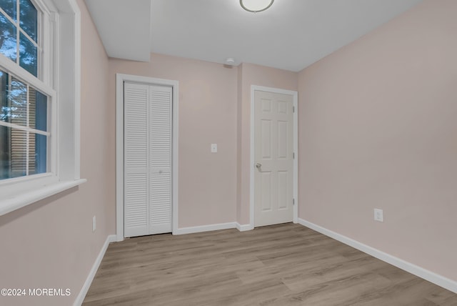 unfurnished bedroom featuring light wood-type flooring and a closet