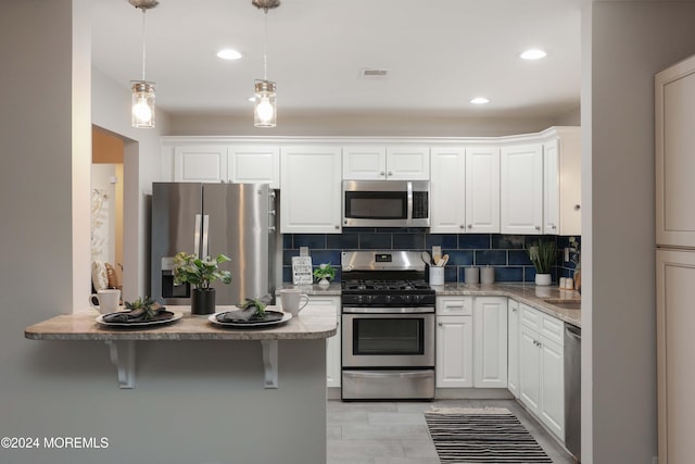 kitchen with stainless steel appliances, tasteful backsplash, pendant lighting, a breakfast bar area, and white cabinets