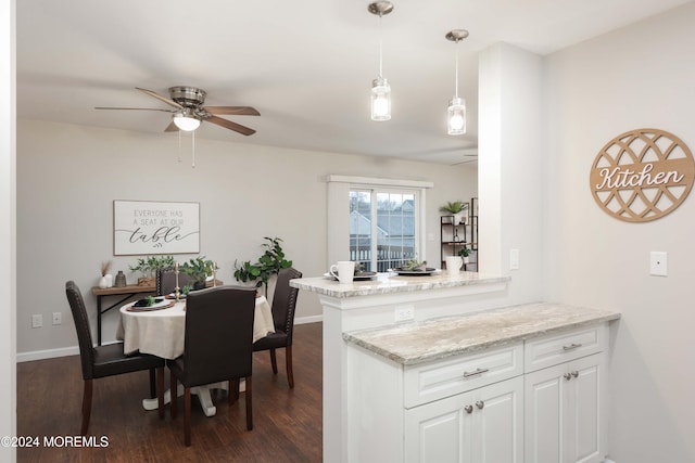 kitchen featuring white cabinetry, ceiling fan, hanging light fixtures, dark hardwood / wood-style flooring, and kitchen peninsula