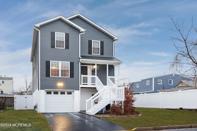 front facade featuring a porch, a garage, and a front yard