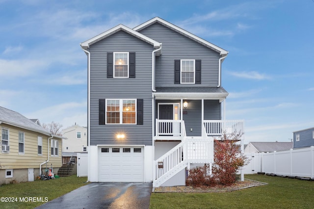 view of front property featuring a porch, a garage, and a front lawn