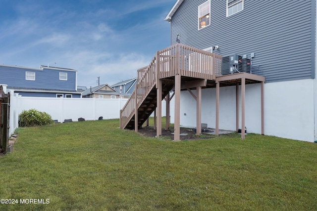 rear view of property featuring a yard, a deck, and central AC unit