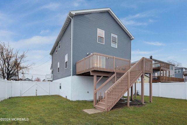 rear view of property featuring a lawn and a wooden deck