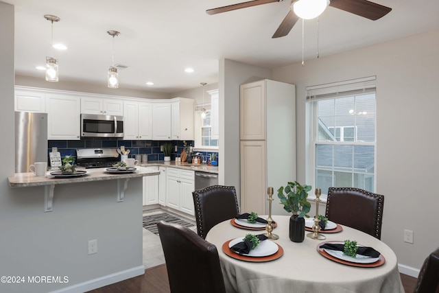 dining area featuring ceiling fan and dark hardwood / wood-style flooring