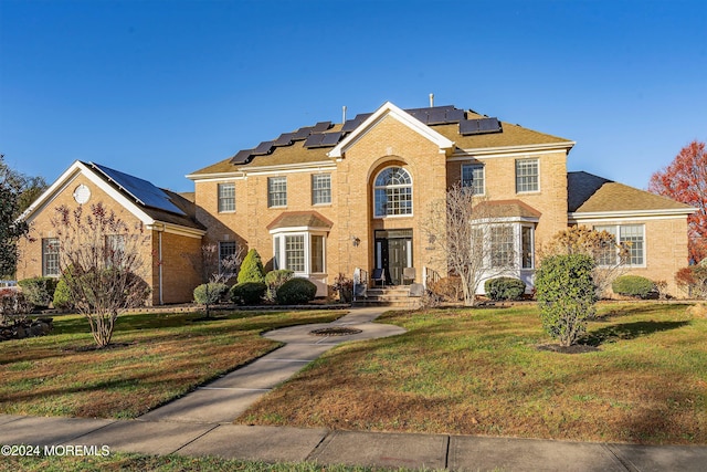 colonial house with a front lawn and solar panels