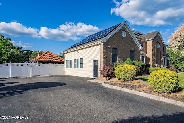 view of side of home with solar panels