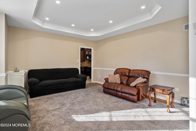 carpeted living room featuring a raised ceiling and crown molding