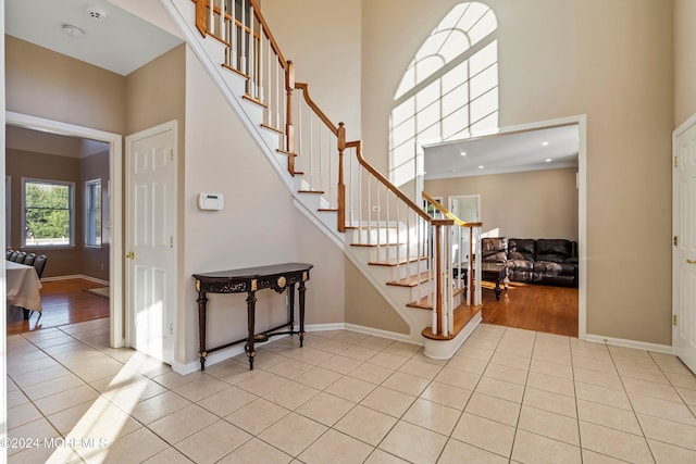 entryway with light hardwood / wood-style floors and a towering ceiling