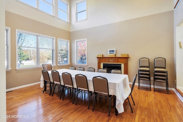 dining area with a towering ceiling and light hardwood / wood-style flooring