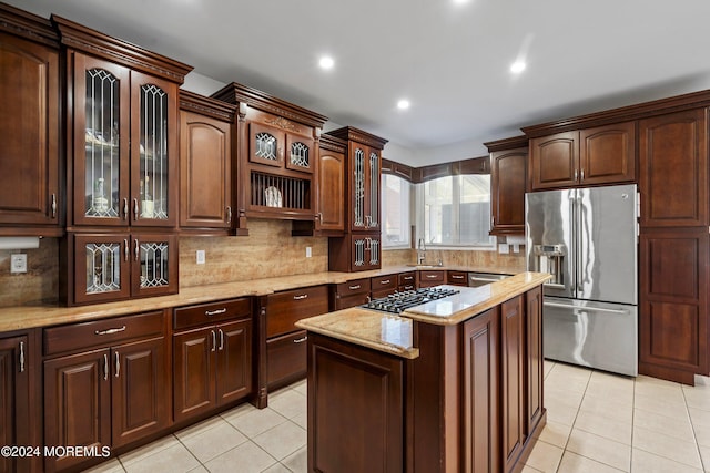 kitchen featuring a center island, sink, light tile patterned floors, dark brown cabinetry, and stainless steel appliances