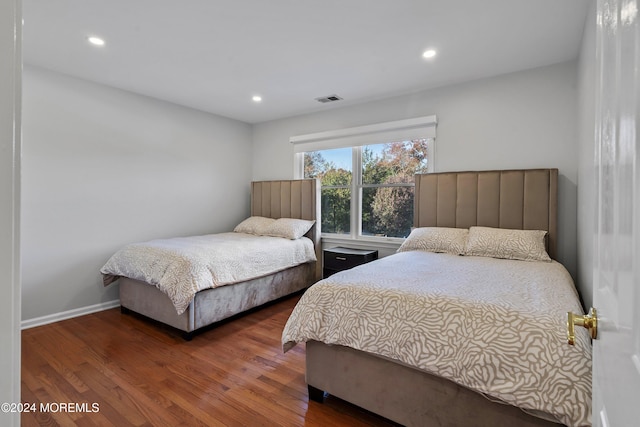 bedroom with dark hardwood / wood-style flooring